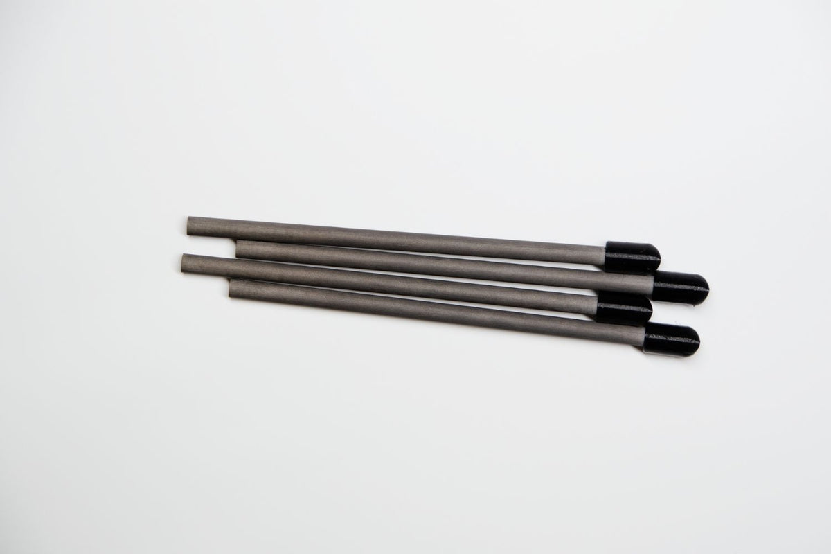 Four long, thin gray rods with black rounded ends, arranged diagonally on a plain white background.