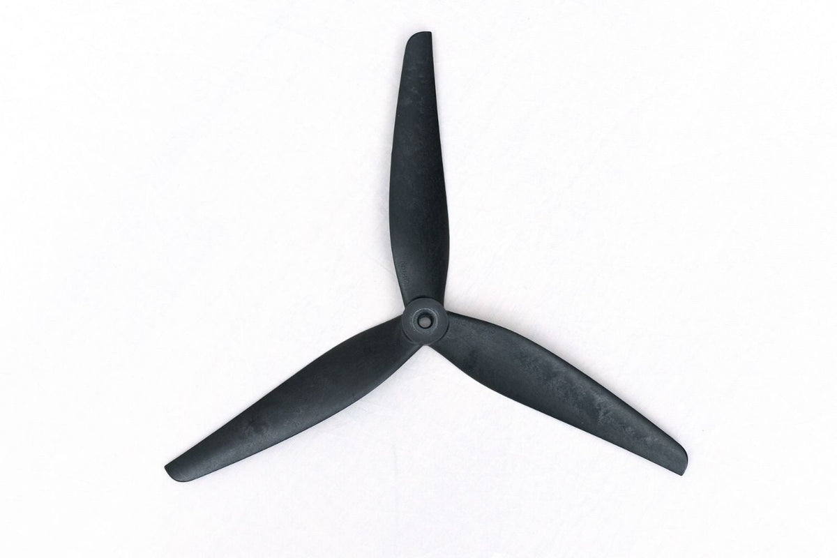 A three-blade black propeller or drone motor blade assembly photographed from above on a plain white background.
