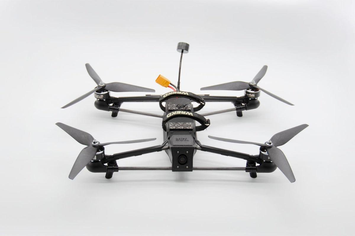 A black quadcopter drone with four gray propellers, shown from a top-down perspective on a clean white background.