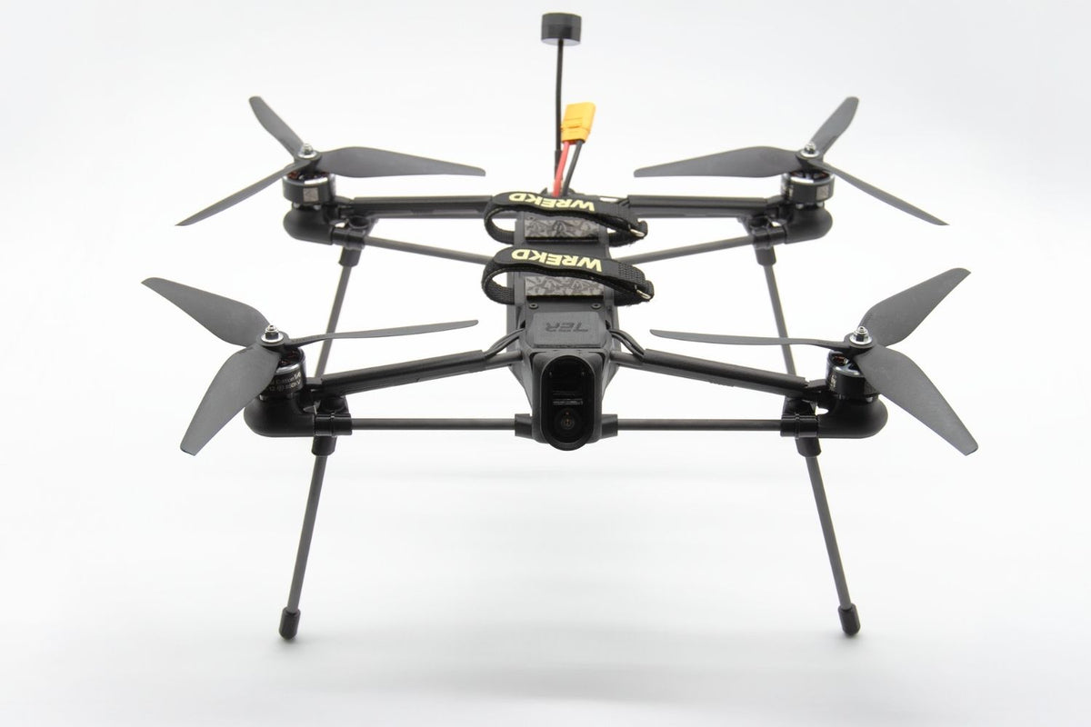 A black quadcopter drone with four propellers and landing legs, featuring a central camera mount 