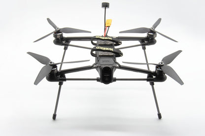 A black quadcopter drone with four propellers and landing legs, featuring a central camera mount 