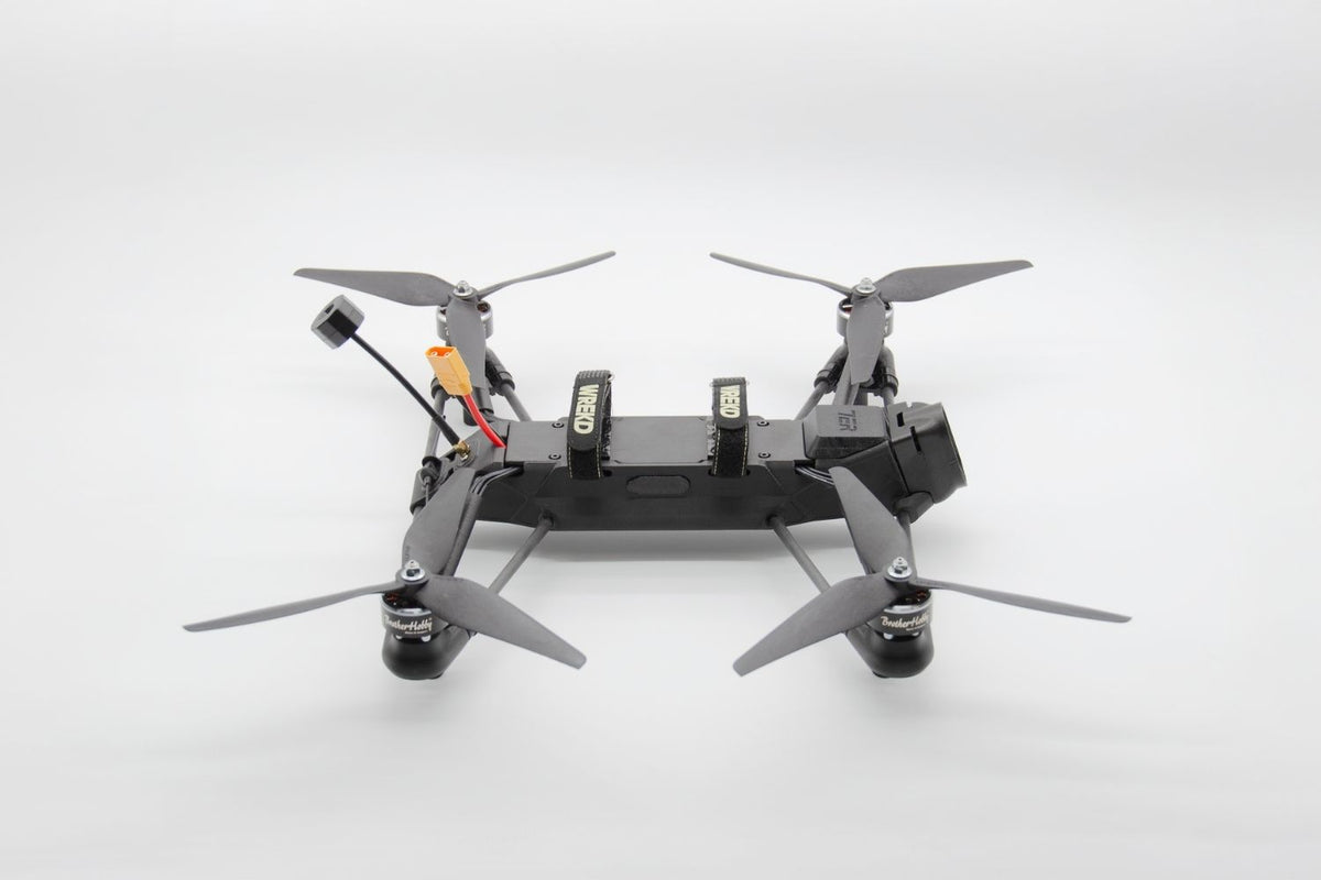 A black quadcopter drone with four gray propellers, shown from a top-down perspective on a clean white studio background.