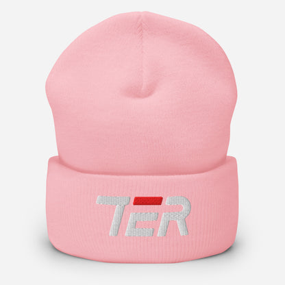 A light pink knit beanie hat with a folded cuff, featuring a white embroidered 'TER' logo with a red accent bar on the front, set against a plain light gray background.