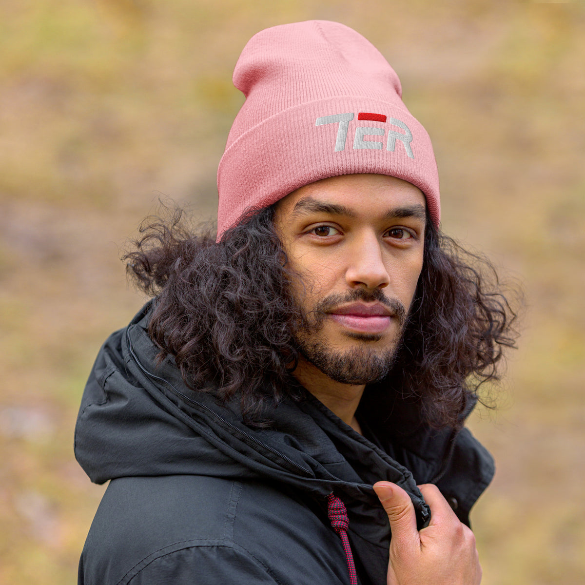 Person wearing a pink beanie with 'TER' text outdoors