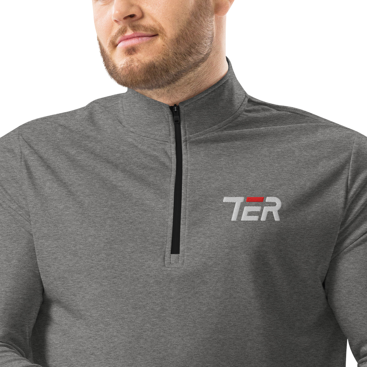 A close-up of a man wearing a heather gray quarter-zip pullover with a white and red 'TER' logo on the left chest, against a plain white background.