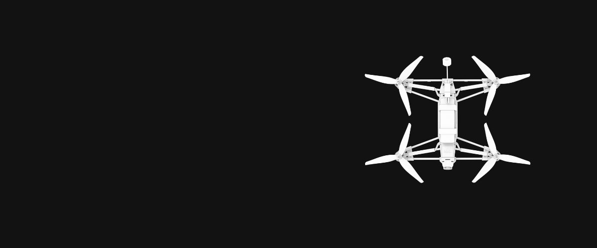 A white quadcopter drone shown from a top-down view on a solid black background.